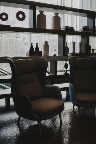a room with two chairs and shelves with vases at The Westin Santa Fe, Mexico City in Mexico City