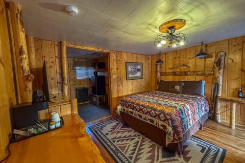 a bedroom with a bed in a room with wooden walls at Chinook Winds Lodge in Dubois
