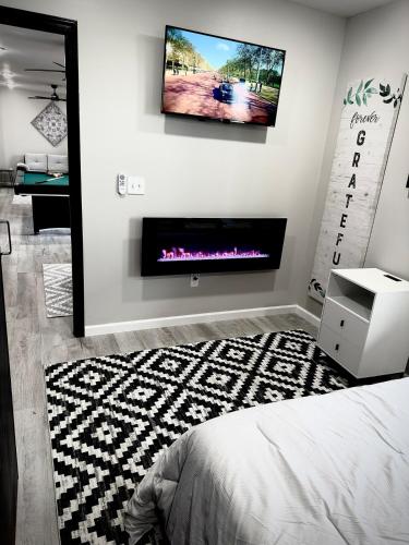 a bedroom with a fireplace and a tv on the wall at Luxury Modern Gatlinburg Cabin Hot Tub and Sauna in Gatlinburg