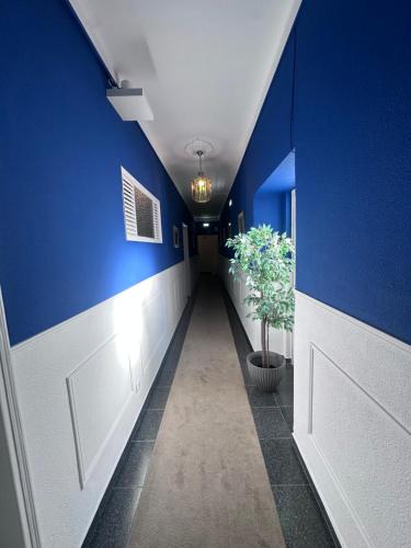 a hallway with a blue wall and a door at Arcada House Tavira in Tavira