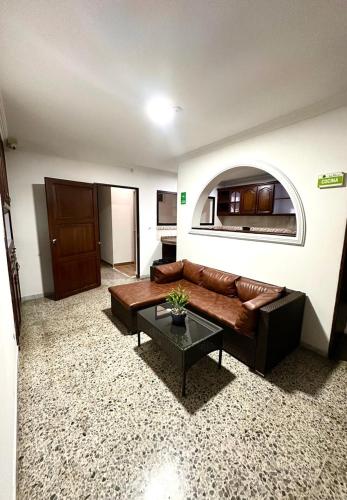 a living room with a brown couch and a table at HOTEL DULCES SUEÑOS N°2 in Tuluá