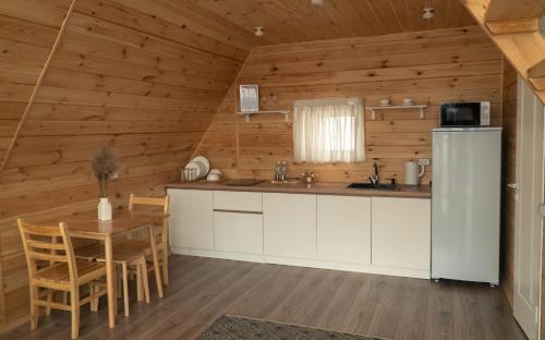 a kitchen and dining room with a refrigerator and a table at Villariba eco-camp in Almaty