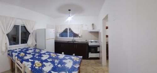 a small kitchen with a table and a refrigerator at Casa Praga in Ostende