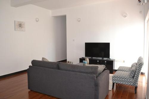 a living room with a couch and a flat screen tv at Luxury Condo in Negombo in Negombo