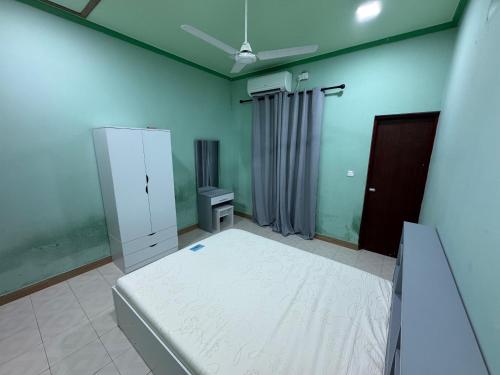 a bedroom with a bed and a cabinet in it at H&F guest house in Maradhoo