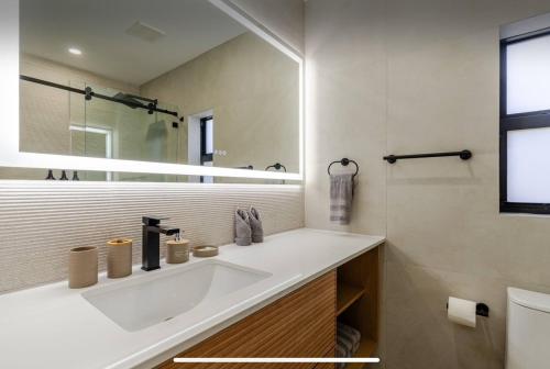 a bathroom with a white sink and a mirror at Miami Oasis by Brickell and Beaches in Miami