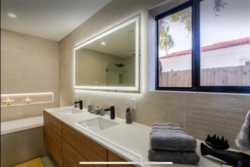 a bathroom with a sink and a large mirror at Miami Oasis by Brickell and Beaches in Miami