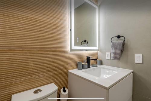 a bathroom with a white sink and a mirror at Miami Oasis by Brickell and Beaches in Miami