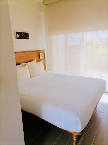 a large white bed in a room with a window at Beach Home at Playa Caracol in Chame