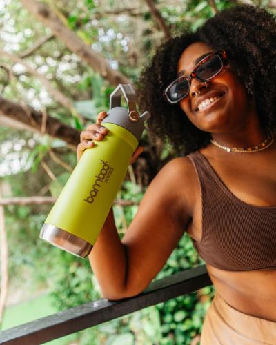 a woman in sunglasses is holding a green bottle at Bamboo Rio Hostel in Rio de Janeiro