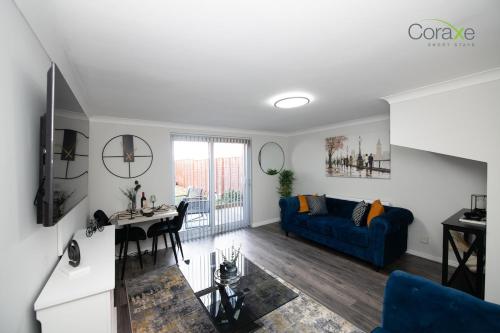 a living room with a blue couch and a table at 2 Bedroom Cosy retreat in West Thurrock