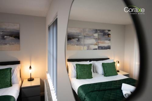 a bedroom with two beds with green pillows at 2 Bedroom Cosy retreat in West Thurrock
