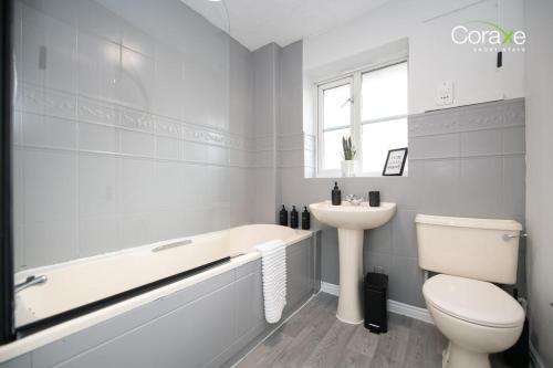 a bathroom with a tub and a toilet and a sink at 2 Bedroom Cosy retreat in West Thurrock