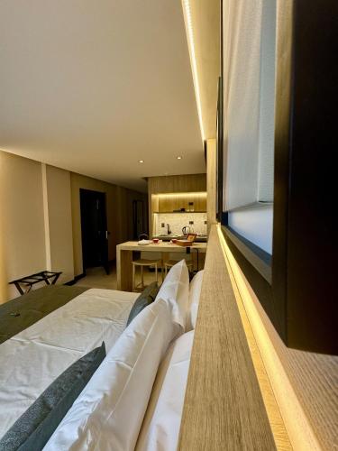 a bedroom with a large bed and a kitchen at Mabra Suites in El Calafate