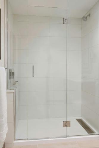a shower with a glass door in a bathroom at Sheraton Saint-Hyacinthe Hotel in Saint-Hyacinthe