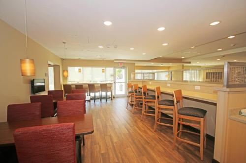 a restaurant with wooden tables and chairs and a bar at TownePlace Suites by Marriott Charleston-North Charleston in Charleston