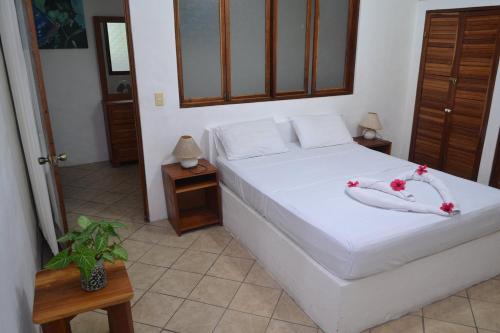a bedroom with a white bed with flowers on it at Condiminium Villas Mymosa in Manuel Antonio