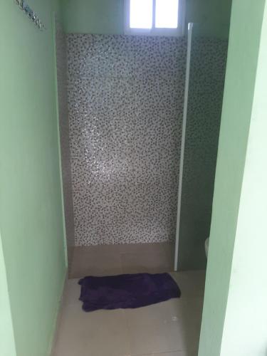 a small bathroom with a shower with a purple towel at Tarde trankila in Sabana de Nisibón