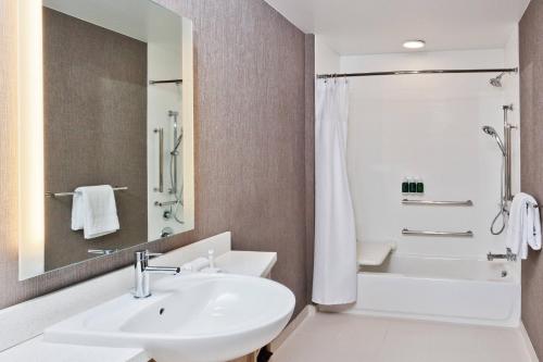 a white bathroom with a sink and a shower at SpringHill Suites by Marriott Montgomery Prattville/Millbrook in Millbrook