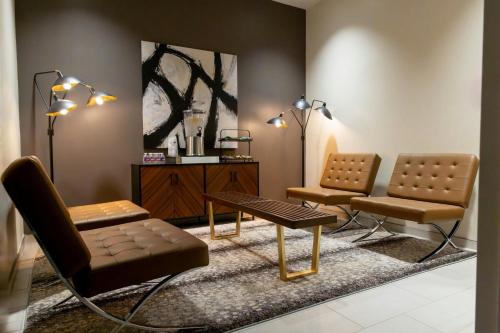 a living room with two chairs and a table at Sheraton Flowood The Refuge Hotel & Conference Center in Flowood
