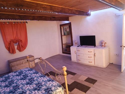 a bedroom with a bed and a dresser with a television at La ca' dal Tunec in Valduggia