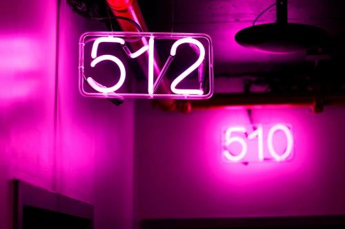 a neon sign that says and a clock at Moxy NYC Downtown in New York