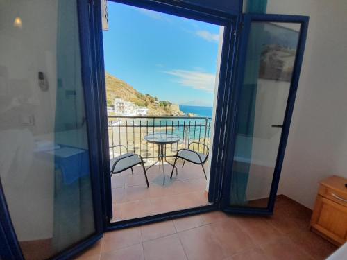 a room with a balcony with a table and chairs at Lydia Mare in Agios Kirykos