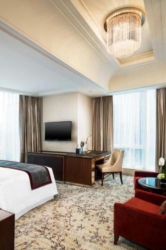 a hotel room with a bed and a flat screen tv at The St. Regis Chengdu in Chengdu