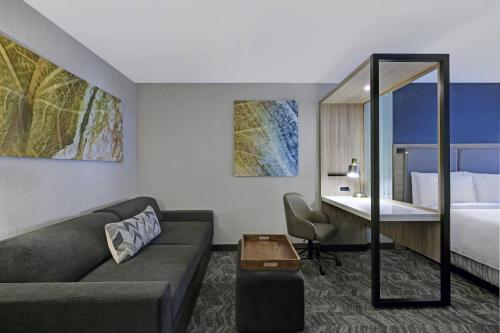 a hotel room with a couch and a bed at SpringHill Suites by Marriott Palm Desert in Palm Desert
