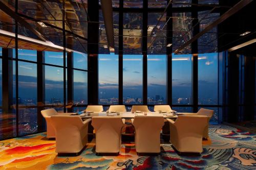 a table and chairs in a room with a large window at The Westin Jakarta in Jakarta