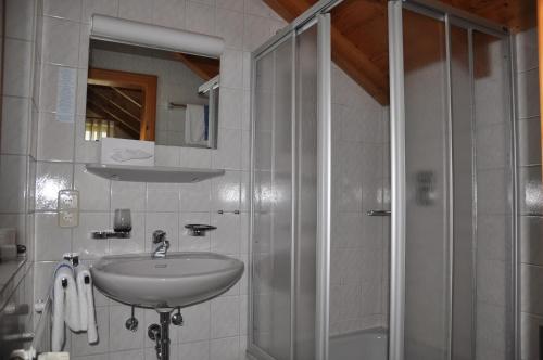 a bathroom with a sink and a shower at Hotel-Pension Breig Garni in Ottenhöfen
