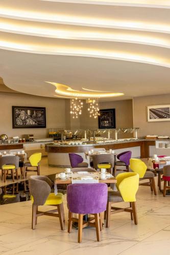 a restaurant with purple and yellow chairs and tables at Sheraton Guadalajara Expo in Guadalajara