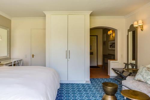 a bedroom with a bed and a living room at Protea Hotel by Marriott Cape Town Mowbray in Cape Town