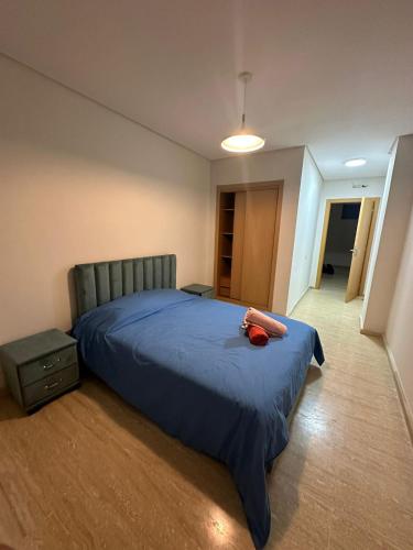 a bedroom with a bed with a red pillow on it at Appartement haut standing Mohammedia Parc in Mohammedia