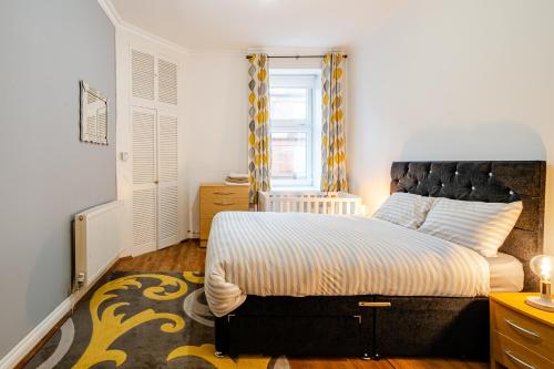 a bedroom with a bed and a window at Newly Furnished Flat 4 Minutes Walk To Metro in Glasgow