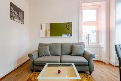 a living room with a couch and a coffee table at Newly Furnished Flat 4 Minutes Walk To Metro in Glasgow