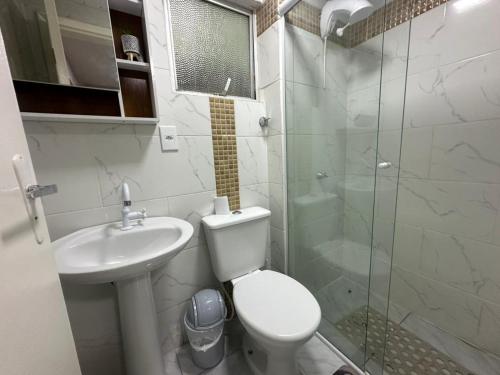 a bathroom with a toilet and a sink and a shower at Studio no coracao do Kobrasol in São José