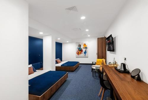a hotel room with two beds and a desk at Kepler Club Riga Airport Hotel - Landside Public Area in Rīga