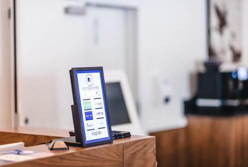 a computer monitor sitting on top of a desk at Kepler Club Riga Airport Hotel - Landside Public Area in Rīga