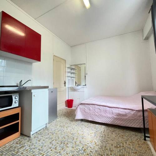 - une cuisine avec un lit et un évier dans la chambre dans l'établissement Galaxy Houses - Charmante maison de vacances, à Vitry-sur-Seine