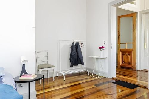 a living room with white walls and a wooden floor at Habitación a orilla del río in Valdivia