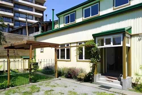 a house with a fence and a building at Habitación a orilla del río in Valdivia