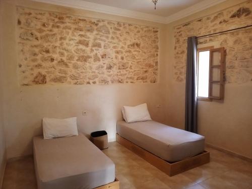 シディ・カウキにあるVilla Taniaのレンガの壁のある部屋にベッドが2つある
