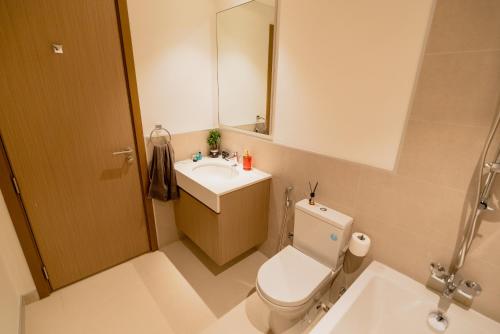 a bathroom with a toilet and a sink and a mirror at Luxurious 3 bedrooms Apartment Maryam Island by Stay Bnb in Sharjah
