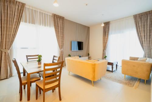a living room with a couch and a table and chairs at Luxurious 3 bedrooms Apartment Maryam Island by Stay Bnb in Sharjah
