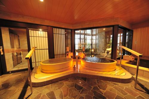 a bathroom with a tub in the middle of a room at Onyado Nono Toyama Natural Hot Spring in Toyama