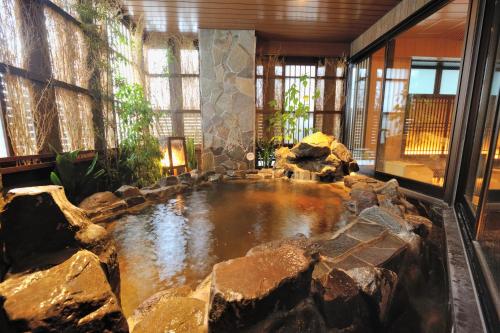 a large pool of water in a room with rocks at Onyado Nono Toyama Natural Hot Spring in Toyama