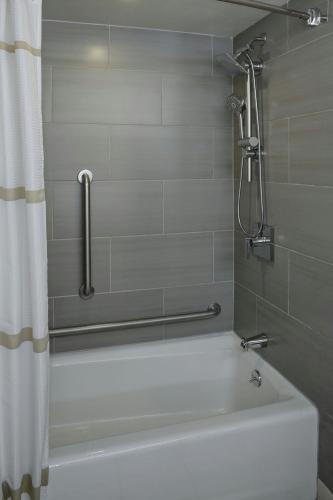 a bathroom with a bath tub with a shower curtain at Marriott East Lansing at University Place in Lansing
