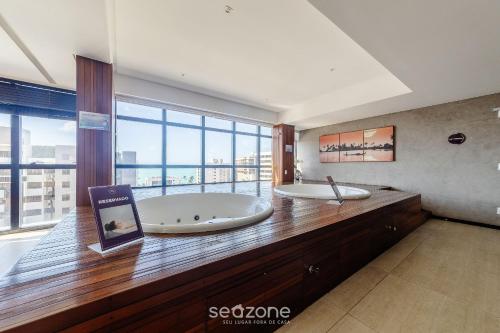 a large bathroom with two tubs on a wooden counter at Estúdio c/ Piscina 300m da Praia - Maceió ETI0724 in Maceió