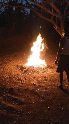 a person is standing in front of a fire at Sweet Villa to experience nature in Virār